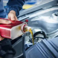 Mechanik wlewa olej do silnika. Zastanawiasz się, ile litrów oleju wchodzi do silnika 2.0? Sprawdź instrukcję swojego auta!
