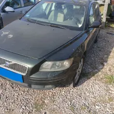 Ciemnozielone Volvo V50 na żwirowisku, widoczny przód auta, kratka Volvo i reflektory. Rozrusznik volvo v50 czeka na montaż.