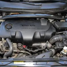 Silnik Volvo 2.4 D5 Common Rail Diesel. Widok komory silnika z widocznym czarnym plastikowym elementem osłaniającym.