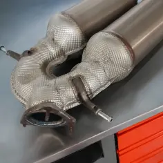 Element układu wydechowego, prawdopodobnie DPF, na metalowym blacie. Zastanawiasz się, ile kosztuje dpf na złomie?