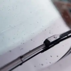 Zbliżenie na mechanizm wycieraczek Volvo V50 z kroplami deszczu na szybie.