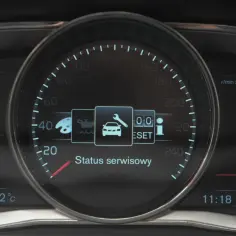 Wyświetlacz Volvo XC60 pokazuje komunikaty ostrzegawcze: status serwisowy, ikonę klucza, reset i informację.