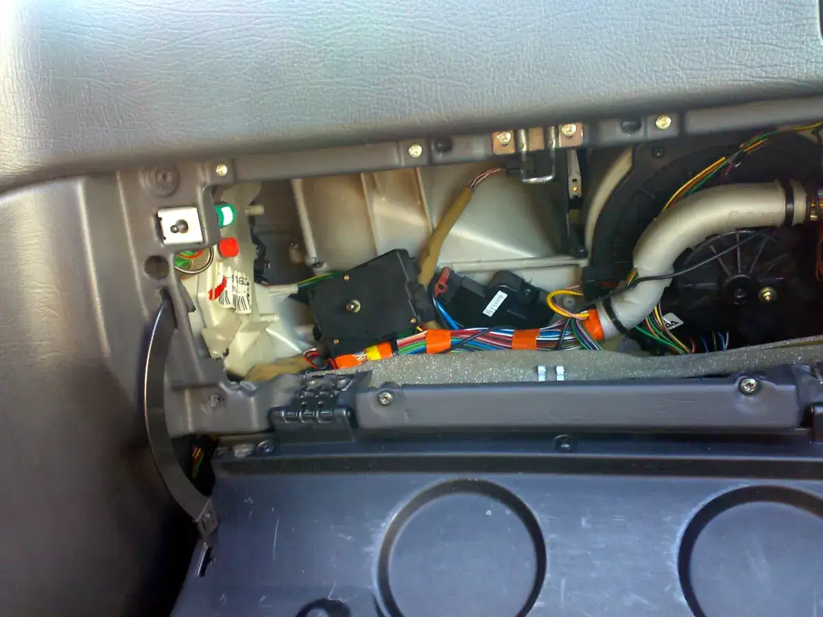 Wnętrze Volvo V50, widok na demontaż schowka i dostęp do silniczka klap nawiewu.