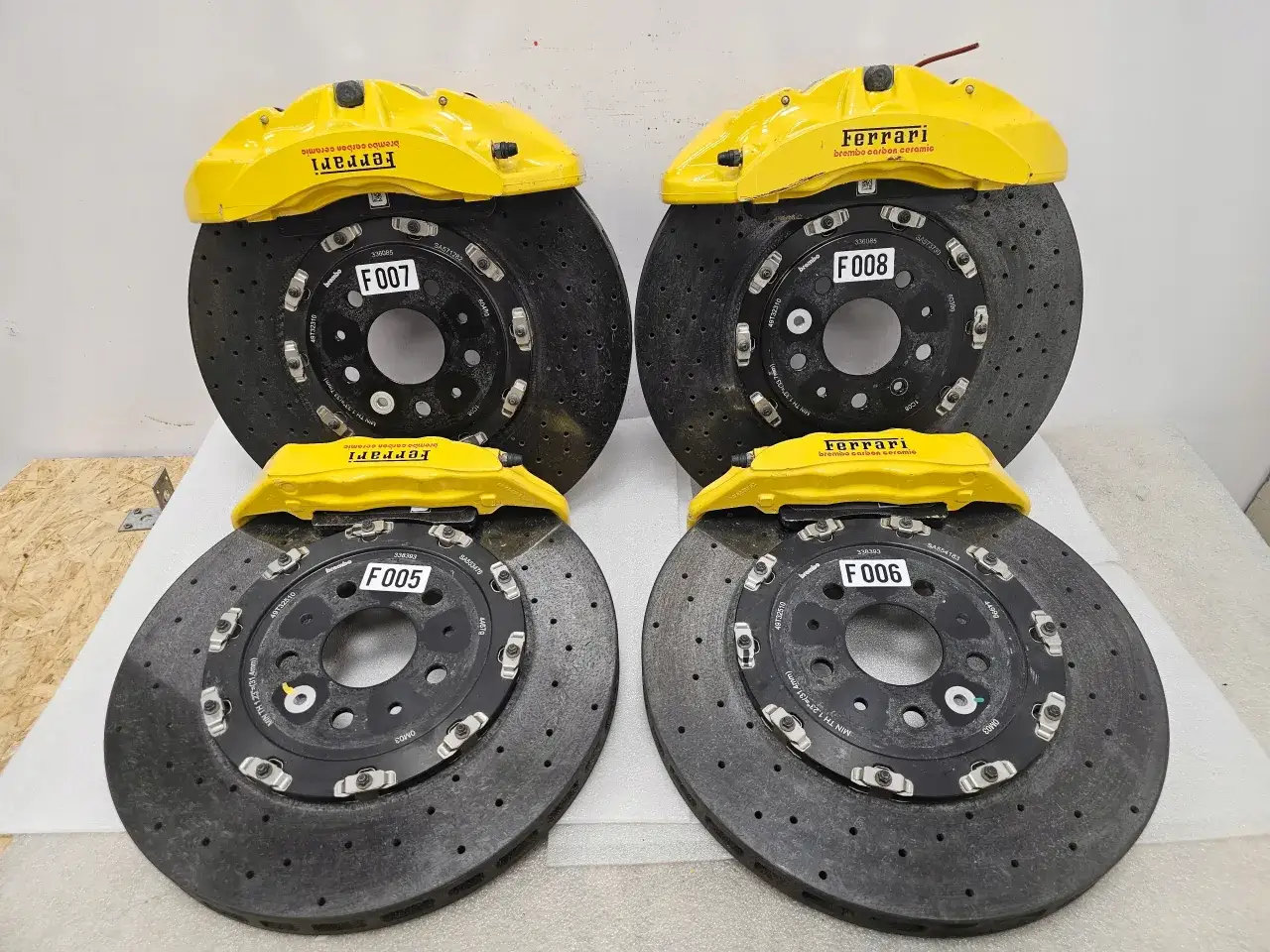 Cztery zestawy hamulców ceramicznych Brembo z żółtymi zaciskami Ferrari. Gotowe do montażu, te gorące tarcze hamulcowe z tyłu zapewnią niezrównaną moc zatrzymania.