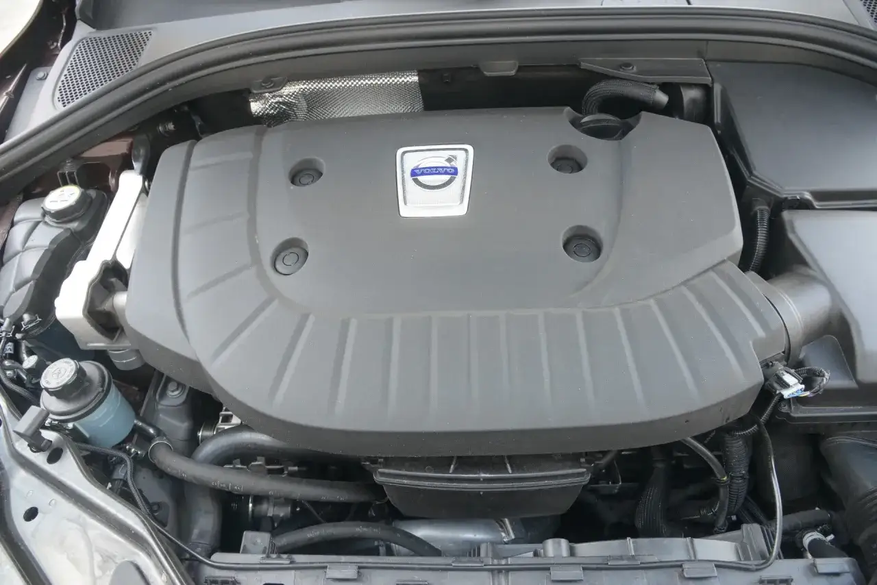 Widok na pokrywę silnika Volvo 2.4 D5 z logo marki. Pod nią ukryte są elementy jednostki napędowej.