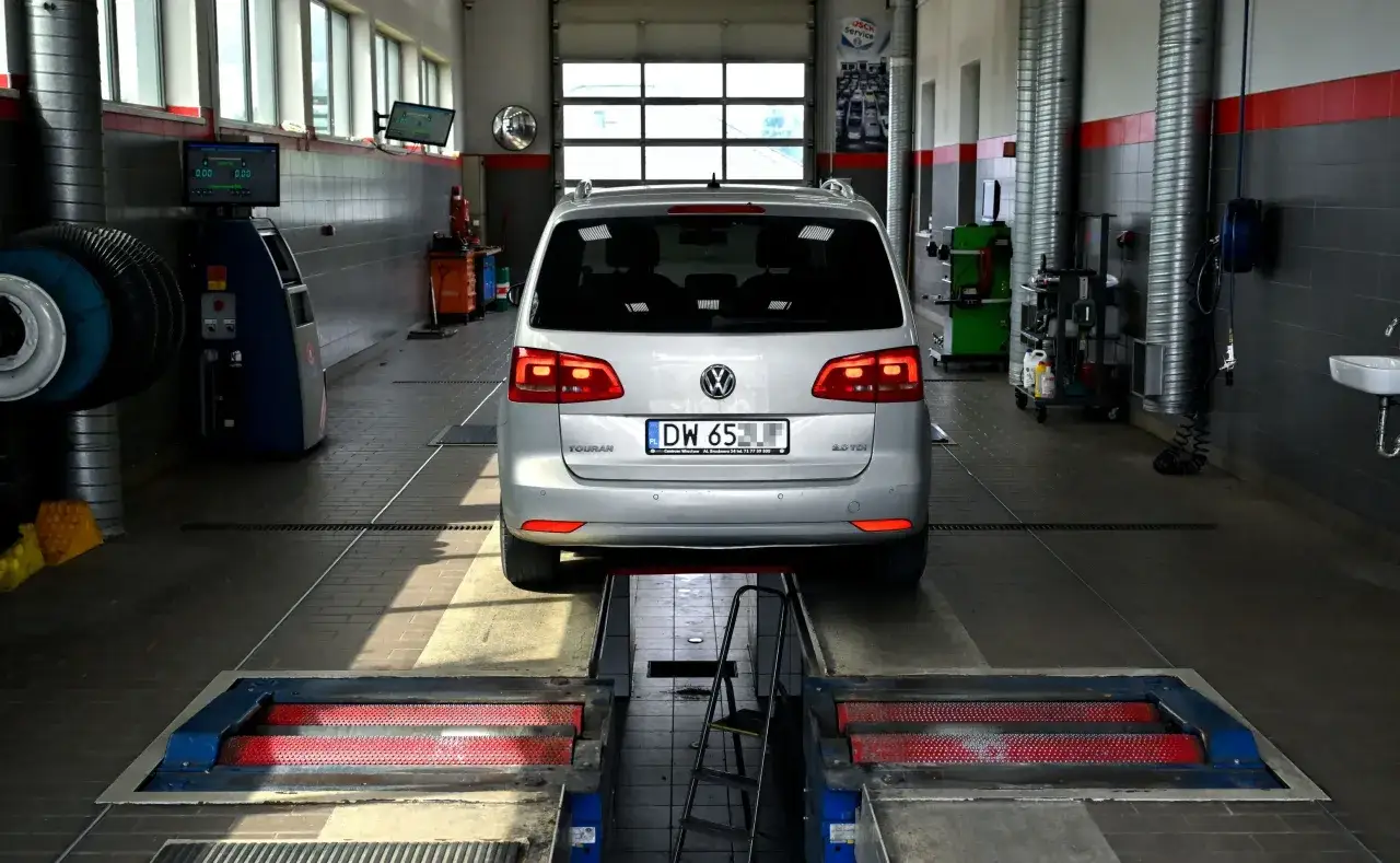 Srebrny Volkswagen Touran 2.0 TDI na rolkach hamowni. Czy warto kupić diesla do miasta? To pytanie zadaje sobie wielu kierowców.