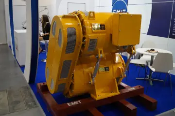 Żółta prądnica synchroniczna EMIT, potężne urządzenie do produkcji energii elektrycznej, prezentowana na targach.